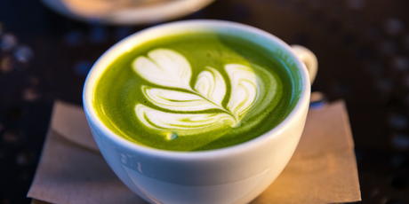 Matcha latte sin lactosa con arte latte en taza blanca. Bebida caliente, cremosa y antioxidante perfecta para disfrutar con estilo y sin culpa.