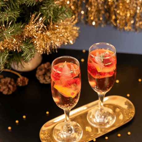 Hielos navideños con Island Oasis Fresa, romero y arándanos rojos. Perfectos para cócteles festivos y brindar con estilo esta temporada.