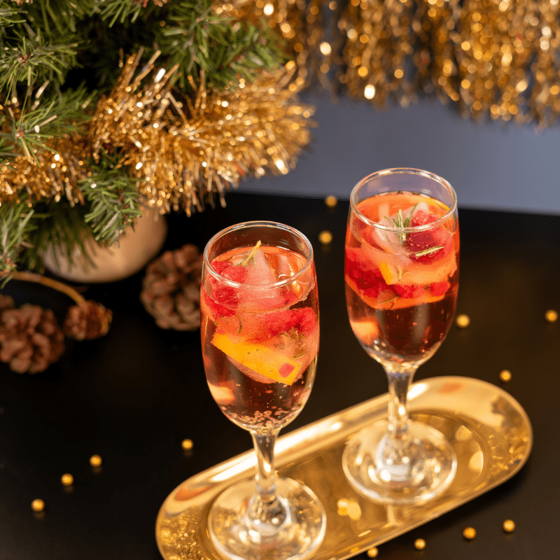 Hielos navideños con Island Oasis Fresa, romero y arándanos rojos. Perfectos para cócteles festivos y brindar con estilo esta temporada.