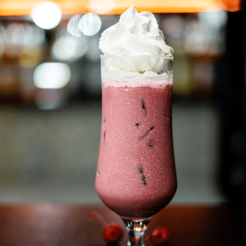 Red Velvet Baileys frappé con crema batida, bebida cremosa con licor servida en copa alta. Ideal para cocteles irresistibles y postres gourmet.