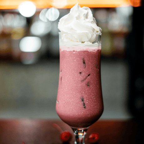 Red Velvet Baileys frappé con crema batida, bebida cremosa con licor servida en copa alta. Ideal para cocteles irresistibles y postres gourmet.