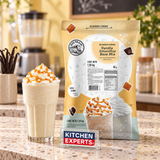 Base Big Train Vanilla Smothie Mix Bolsa 1.59 kg con bebida preparada y letrero Kitchen Experts integrado en la escena