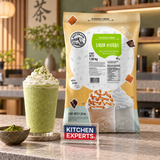 Base Big Train Manzana Chai Especiado 1590 Gramos con bebida preparada y letrero Kitchen Experts integrado en la escena