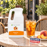 Concentrado Durazno Tea Zone 1.9 Litros con bebida preparada y letrero Kitchen Experts integrado en la escena
